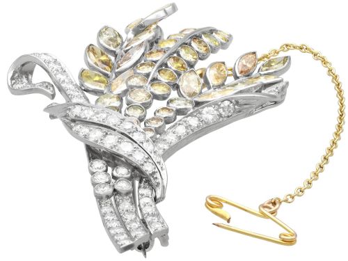 fig 5. An Art Deco diamond brooch designed as a stylized flower spray with yellow and white diamonds mounted in palladium with a safety chain.