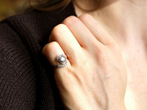 fig 2. An antique 18ct yellow gold twist ring featuring a central round diamond set within a swooping platinum accent band set with smaller diamonds.