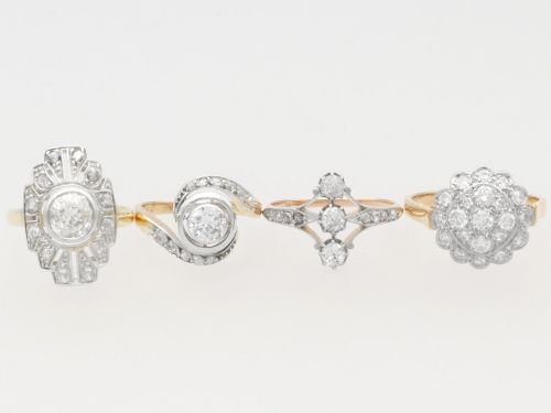 fig 6. An antique 18ct yellow gold twist ring featuring a central round diamond set within a swooping platinum accent band set with smaller diamonds.
