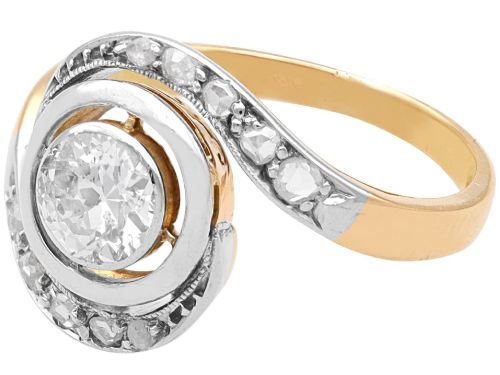 fig 7. An antique 18ct yellow gold twist ring featuring a central round diamond set within a swooping platinum accent band set with smaller diamonds.