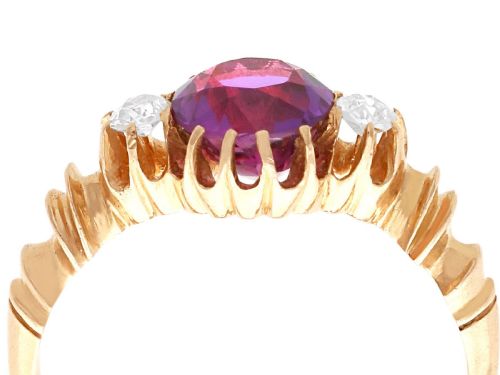 fig 6. A Victorian 15ct rose gold trilogy ring set with a central purple sapphire flanked by two diamonds on carved shoulders.
