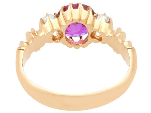 fig 8. A Victorian 15ct rose gold trilogy ring set with a central purple sapphire flanked by two diamonds on carved shoulders.