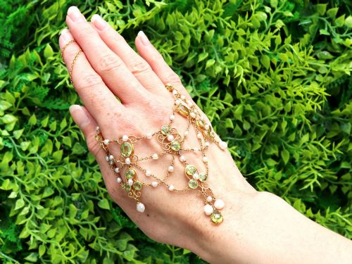 fig 1. An 18ct yellow gold Belle Epoque festoon necklace featuring faceted green peridots, intricate scrollwork, and suspended natural pearl drops.