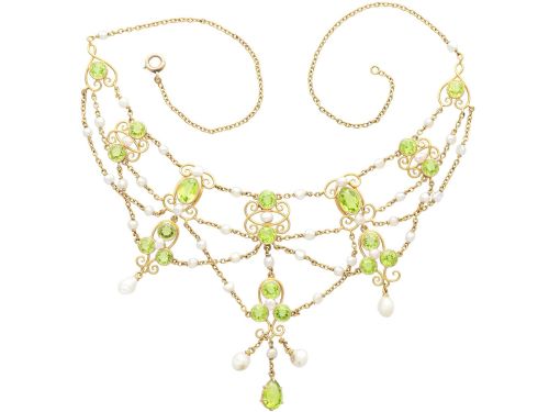fig 6. An 18ct yellow gold Belle Epoque festoon necklace featuring faceted green peridots, intricate scrollwork, and suspended natural pearl drops.