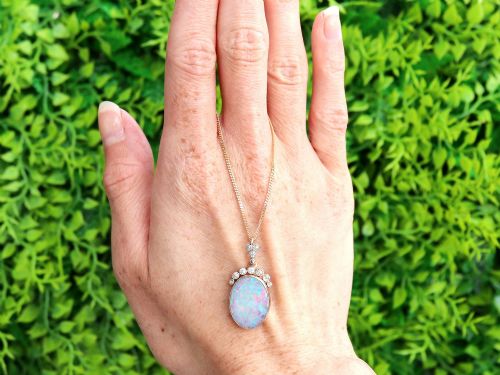fig 1. An Edwardian 9ct yellow gold pendant featuring an oval cabochon opal surmounted by millegrain-set diamonds.