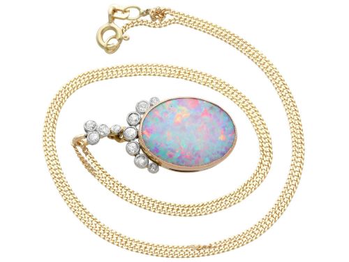 fig 8. An Edwardian 9ct yellow gold pendant featuring an oval cabochon opal surmounted by millegrain-set diamonds.