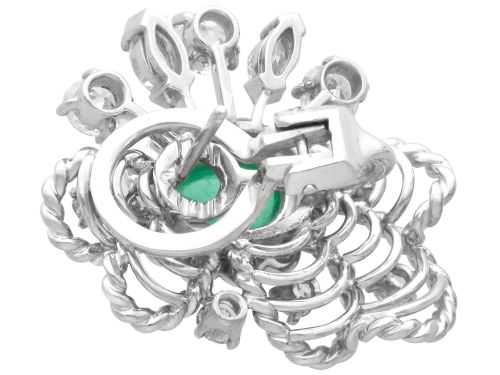 fig 6. A pair of platinum and palladium clip earrings featuring oval central emeralds surrounded by brilliant-cut diamonds and rope-twist metalwork.