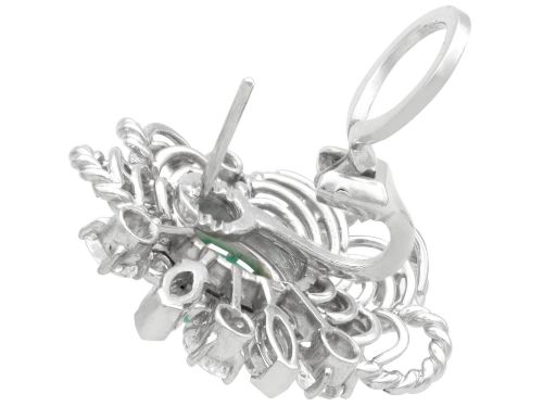 fig 7. A pair of platinum and palladium clip earrings featuring oval central emeralds surrounded by brilliant-cut diamonds and rope-twist metalwork.