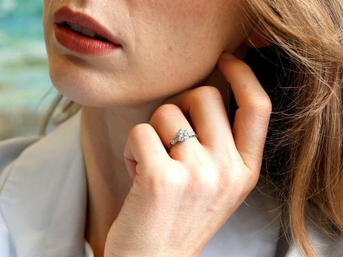 fig 4. A platinum solitaire ring set with a central round diamond and smaller diamond accents on the shoulders.