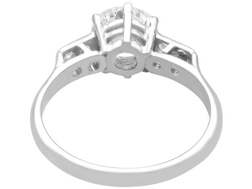 fig 6. A platinum solitaire ring set with a central round diamond and smaller diamond accents on the shoulders.