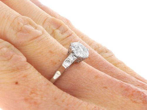 fig 9. A platinum solitaire ring set with a central round diamond and smaller diamond accents on the shoulders.