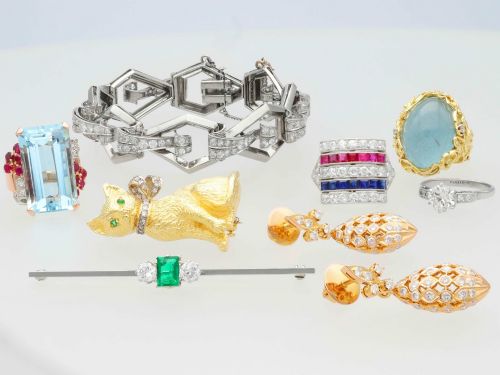 fig 5. An antique 18ct white gold bar brooch featuring a central rectangular emerald cut emerald flanked by two round diamonds on a slender horizontal metal bar.