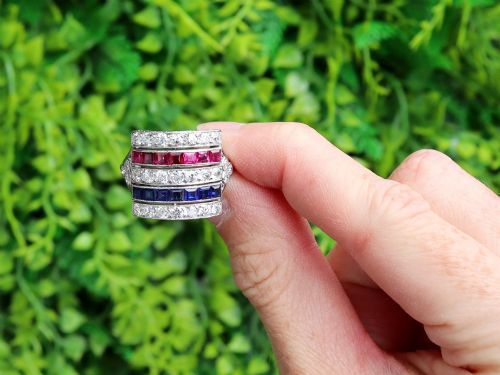 fig 1. An antique platinum ring displaying horizontal rows of round diamonds alternating with channel-set rectangular blue sapphires and red rubies.