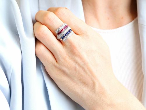fig 3. An antique platinum ring displaying horizontal rows of round diamonds alternating with channel-set rectangular blue sapphires and red rubies.