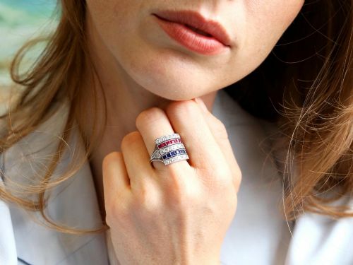 fig 4. An antique platinum ring displaying horizontal rows of round diamonds alternating with channel-set rectangular blue sapphires and red rubies.