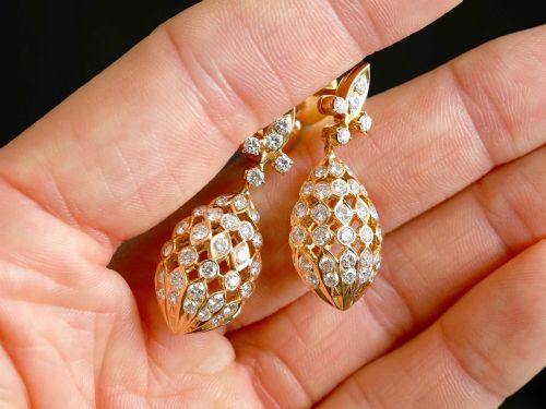 fig 2. A pair of 18ct yellow gold drop earrings featuring fleur-de-lis surmounts above openwork teardrop cages set with round diamonds.
