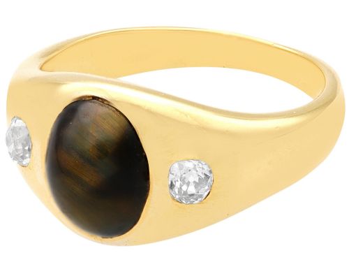 fig 4. An 18ct yellow gold ring set with a central oval cabochon tigers eye stone flanked by two flush-set diamonds.