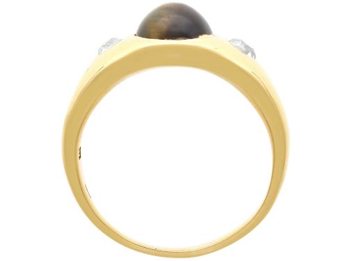fig 6. An 18ct yellow gold ring set with a central oval cabochon tigers eye stone flanked by two flush-set diamonds.