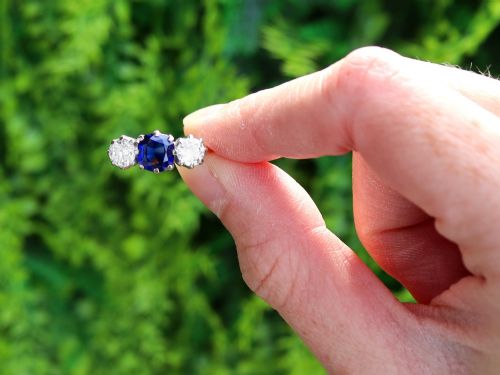 fig 1. An antique 18ct yellow gold trilogy ring featuring a cushion-shaped blue sapphire flanked by two brilliant-cut diamonds in claw settings.