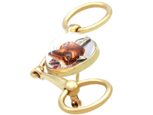 fig 4. An antique 14ct yellow gold brooch designed as an equestrian snaffle bit with a central round reverse intaglio rock crystal depicting a painted fox mask.