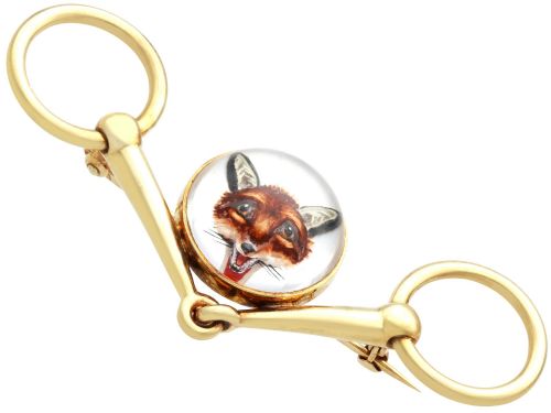 fig 5. An antique 14ct yellow gold brooch designed as an equestrian snaffle bit with a central round reverse intaglio rock crystal depicting a painted fox mask.