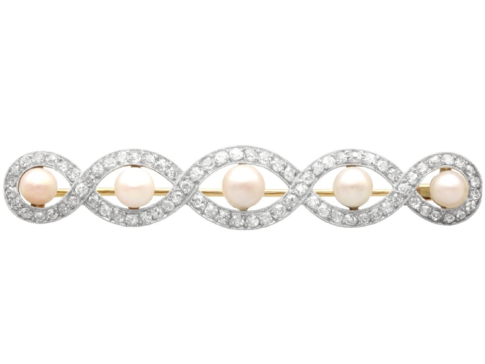 An Art Deco gold bar brooch featuring five natural pearls framed within a diamond-set intertwined ribbon setting.