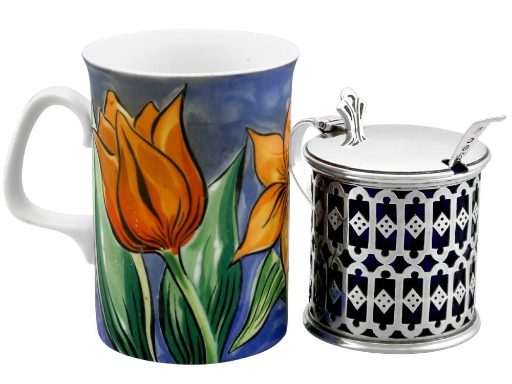 A pierced sterling silver mustard pot featuring geometric openwork, a cobalt blue glass liner, a flat hinged lid, and an accompanying spoon. View III
