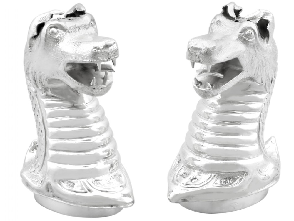 A pair of antique Victorian sterling silver pepper casters sculpted in the form of detailed dragon heads.