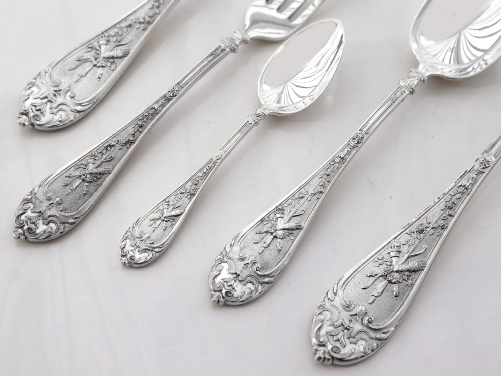 Victorian sterling silver flatware pieces displaying intricate foliate engraving and gilt bowls against a white backdrop. View III