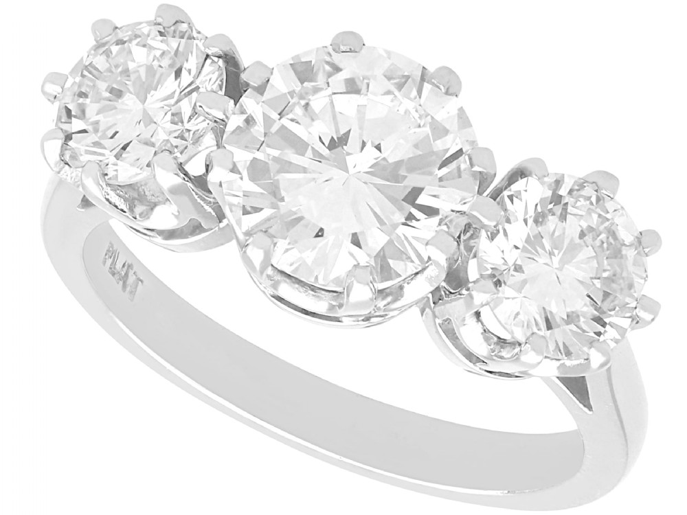 A platinum trilogy ring featuring three round brilliant cut diamonds set in individual multi-claw settings along a polished platinum band.