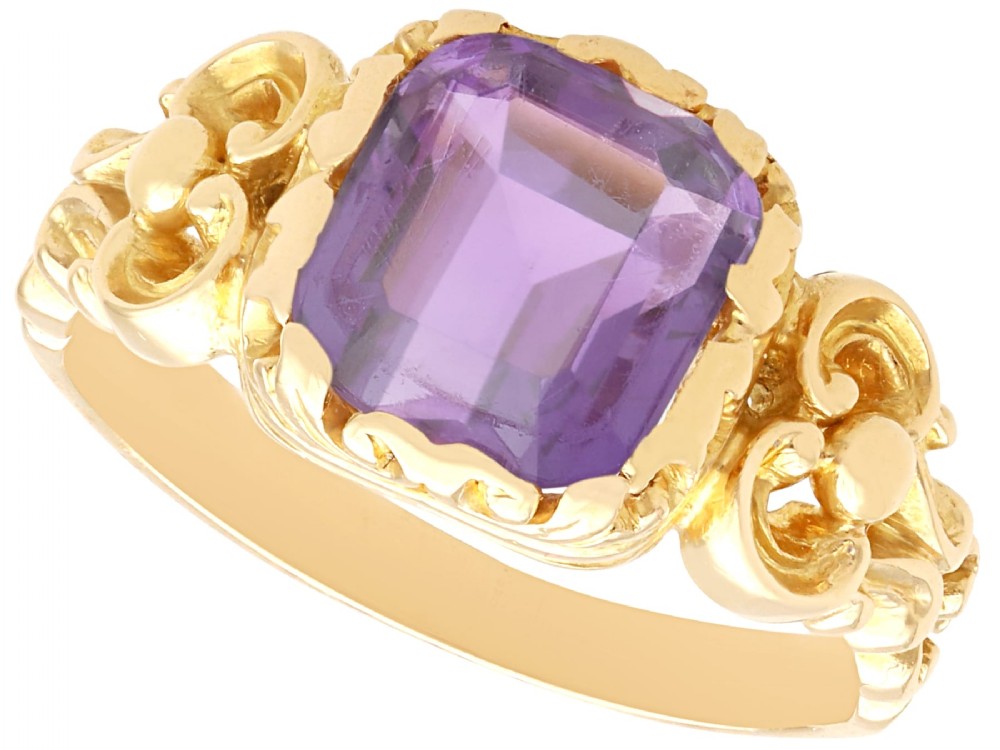 An antique 15ct yellow gold ring featuring an emerald-cut purple amethyst gemstone with detailed scrollwork on the shoulders.