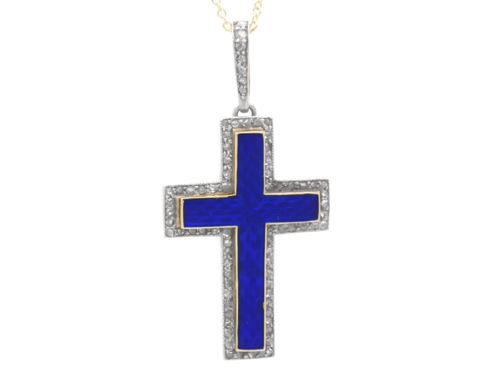 An antique Victorian cross pendant featuring cobalt blue enamel framed by small diamonds set in metal atop a 15ct yellow gold backing.