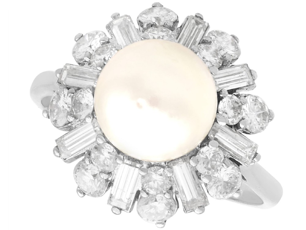 A platinum cluster ring featuring a central white cultured pearl surrounded by a starburst halo of baguette and brilliant-cut diamonds.