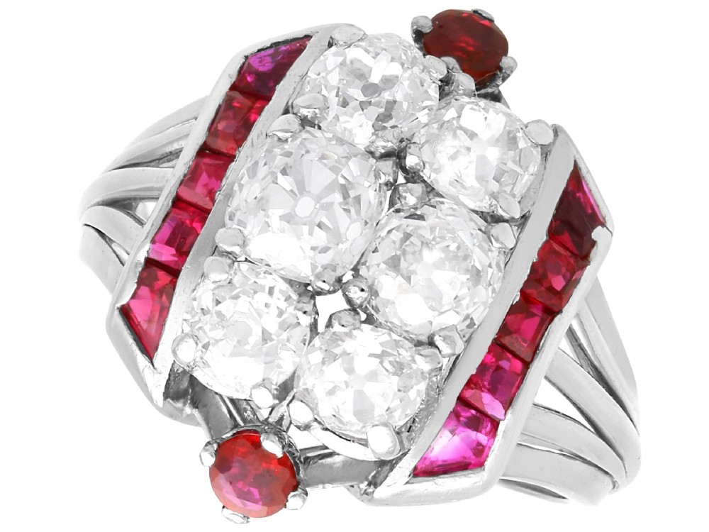 An Art Deco 18ct white gold dress ring featuring a central cluster of old-cut diamonds flanked by channel-set calibre rubies.