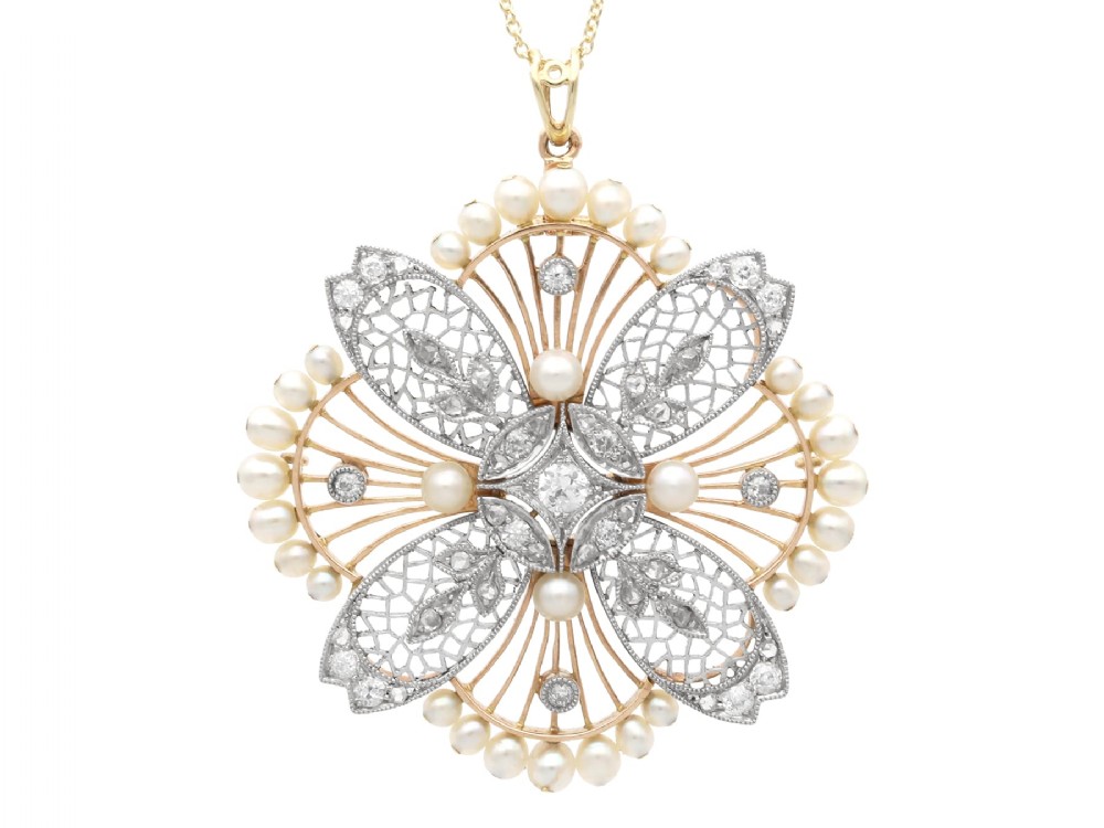 An openwork circular Edwardian floral pendant brooch crafted in rose gold and platinum, set with central diamonds and a perimeter of natural pearls.
