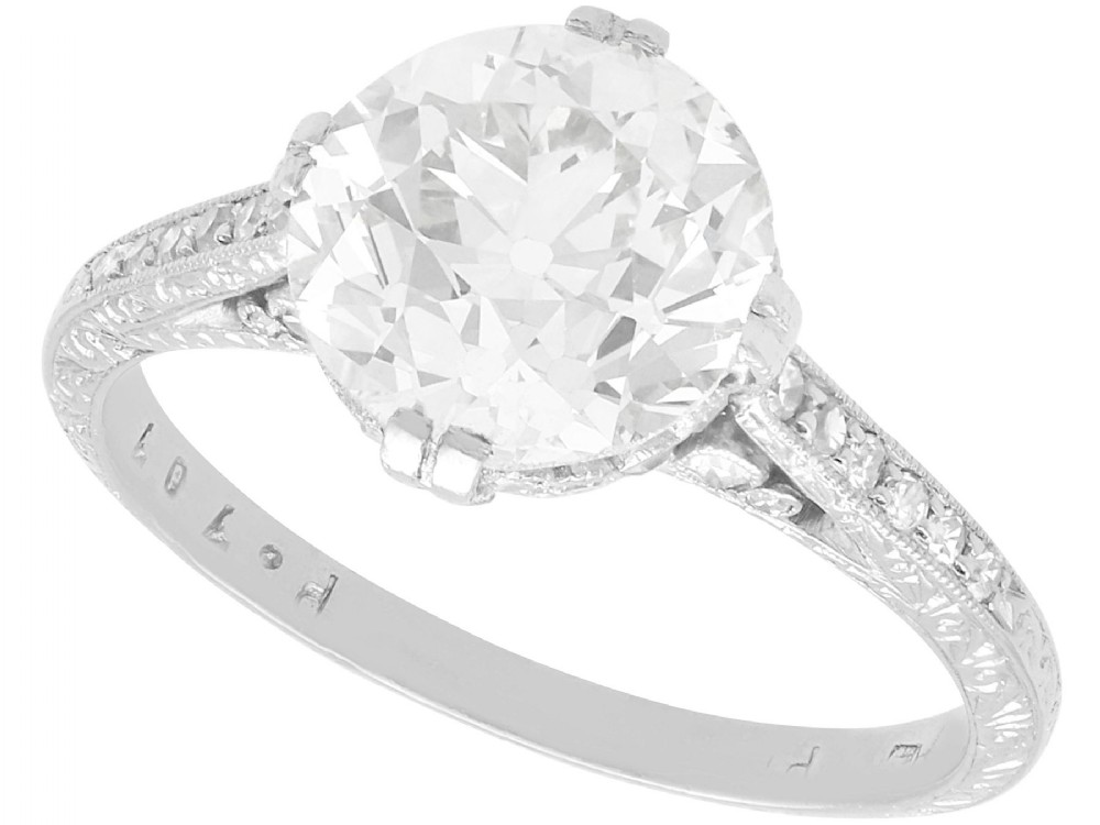 A platinum solitaire ring featuring a large round diamond secured by multi-claw prongs on a hand-engraved decorative band.