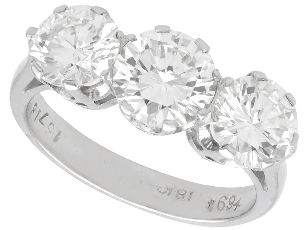A vintage 18ct white gold trilogy ring featuring three round brilliant cut diamonds set in claw settings.