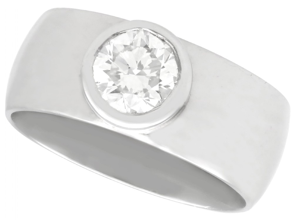 A vintage 14ct white gold wide band ring featuring a central bezel-set round brilliant diamond.