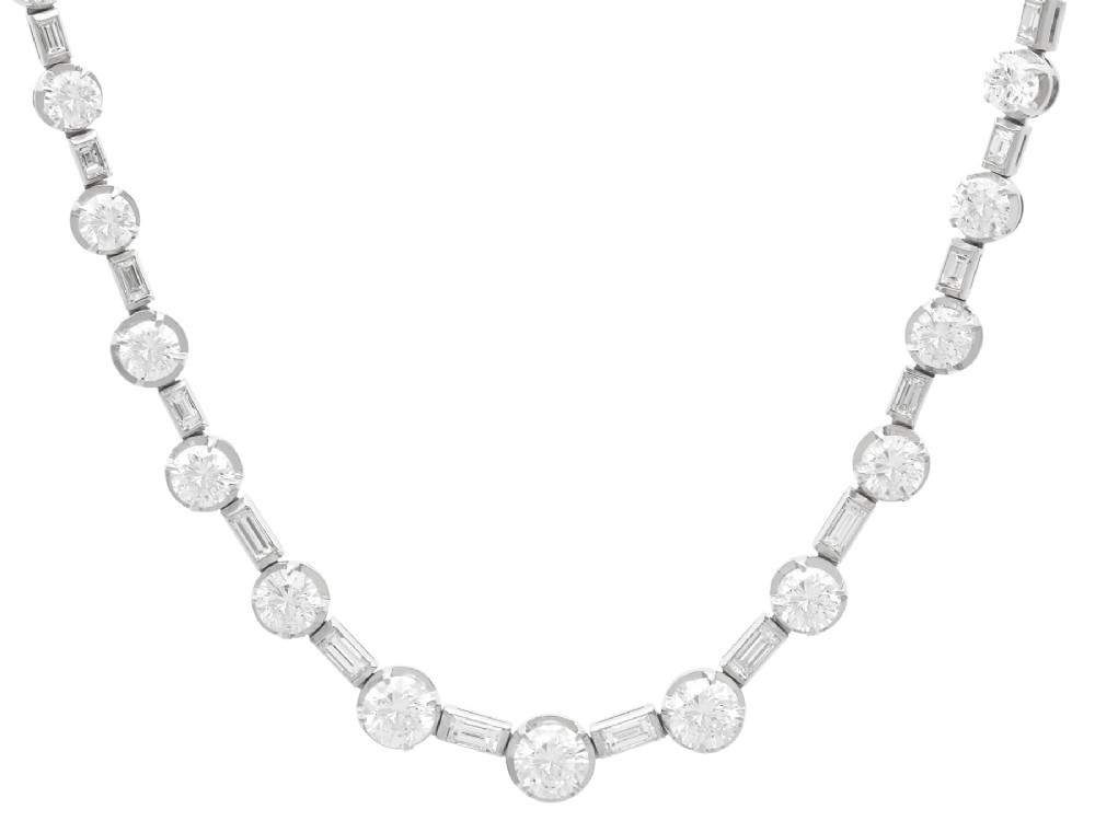 An antique Art Deco platinum necklace set with alternating round cut and baguette cut diamonds linked in a continuous line.