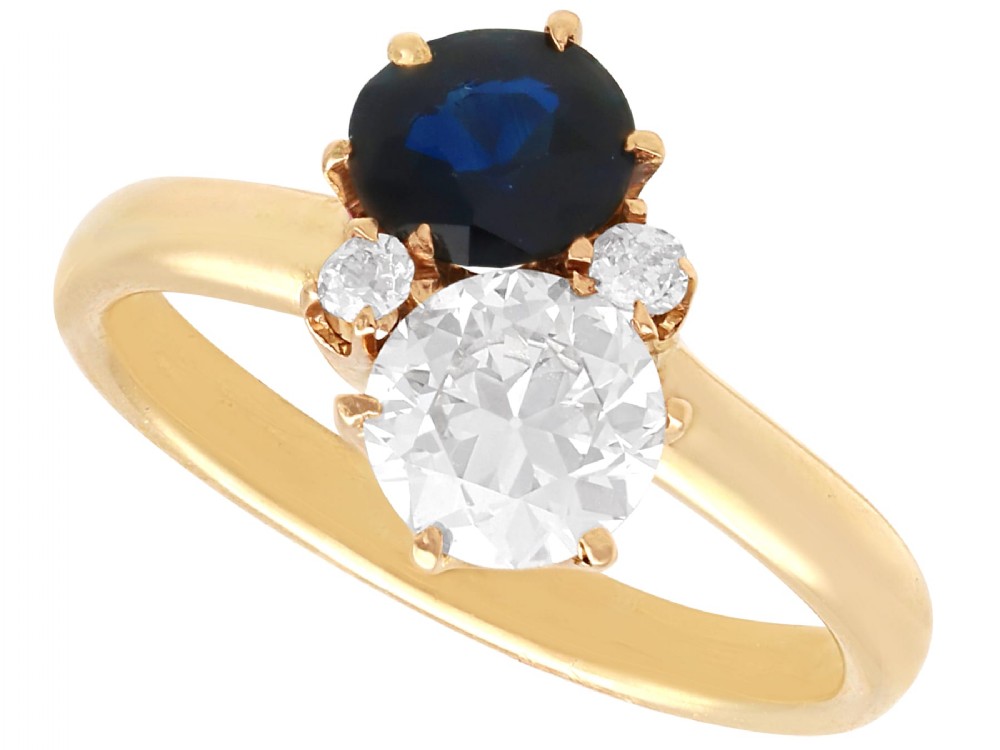 An antique 14ct yellow gold ring featuring an oval blue sapphire paired with a round diamond and small accent stones in claw settings.