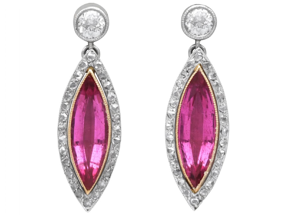 Pair of Art Deco platinum drop earrings featuring navette-cut pink tourmalines bordered by small diamonds, suspended from round diamond studs.