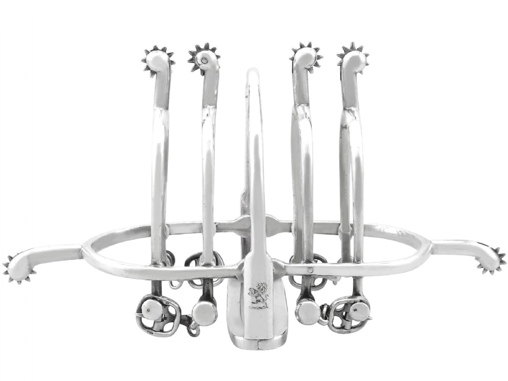An antique sterling silver toast rack designed with equestrian riding spurs and rowels.