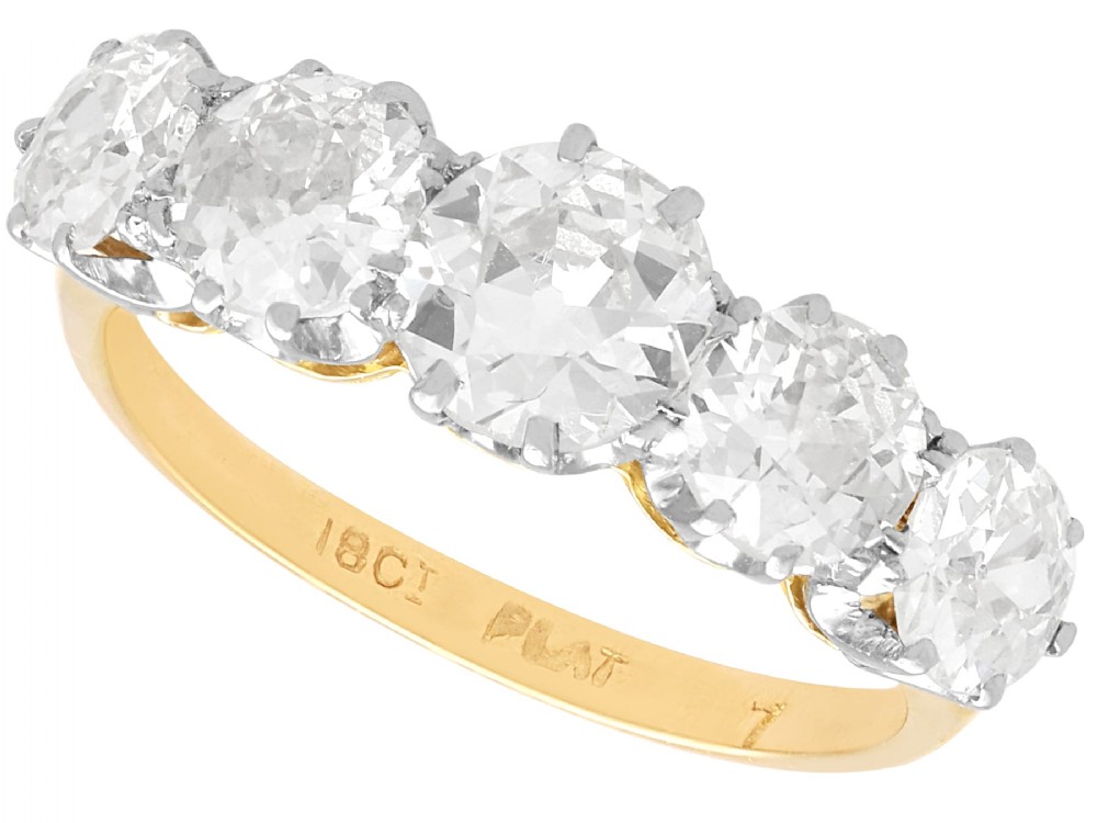 An 18ct yellow gold and platinum ring featuring five claw-set round diamonds arranged horizontally in a row.