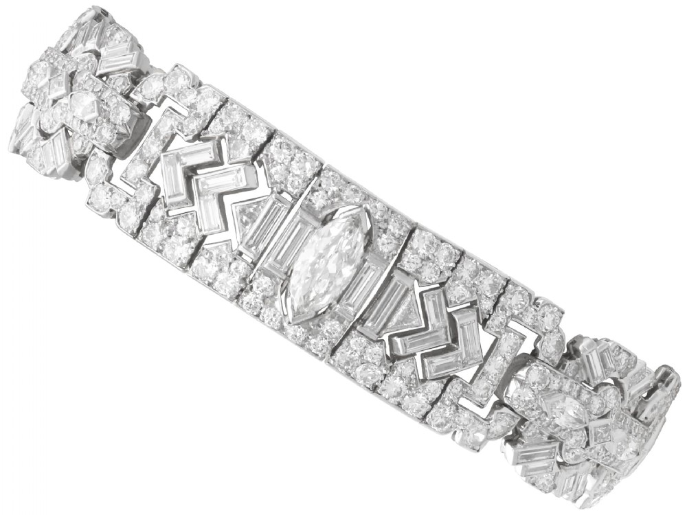 An Art Deco platinum bracelet set with a central marquise diamond and surrounding geometric rows of baguette and round diamonds.