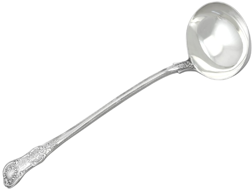 An antique Victorian sterling silver soup ladle in Queens pattern featuring a deep round bowl and an intricately carved handle.