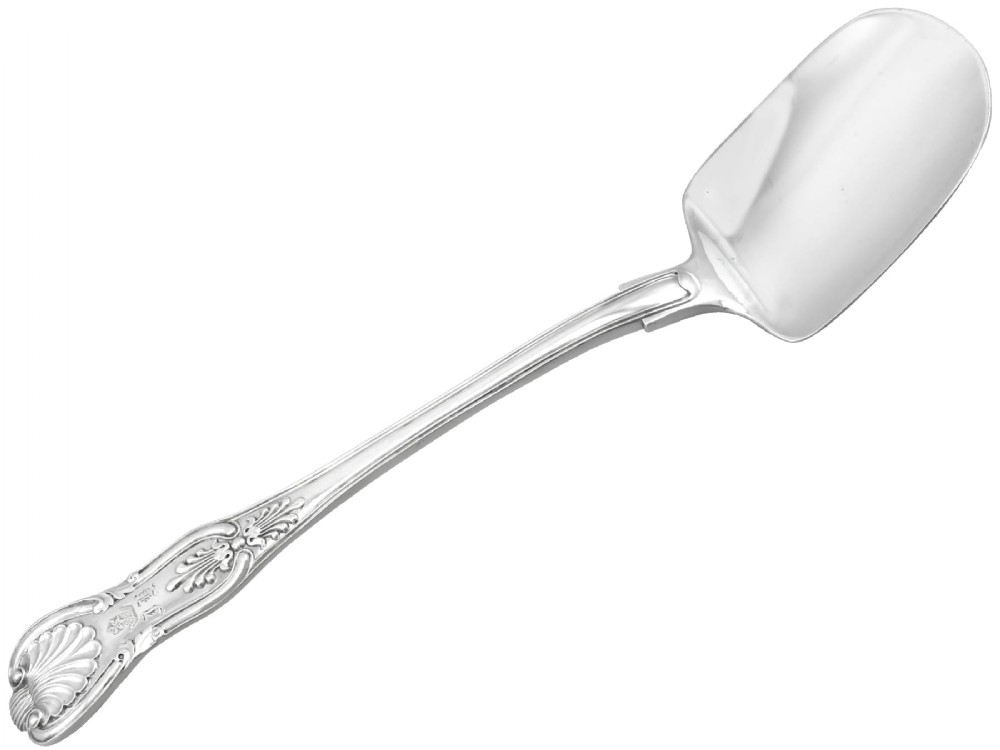 An antique William IV sterling silver ice cream server featuring a broad shovel-shaped blade and a handle decorated with a shell motif.
