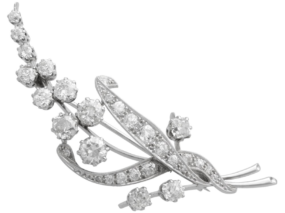 An antique 18ct white gold floral spray brooch set with round diamonds in a stylized leaf sprig design.