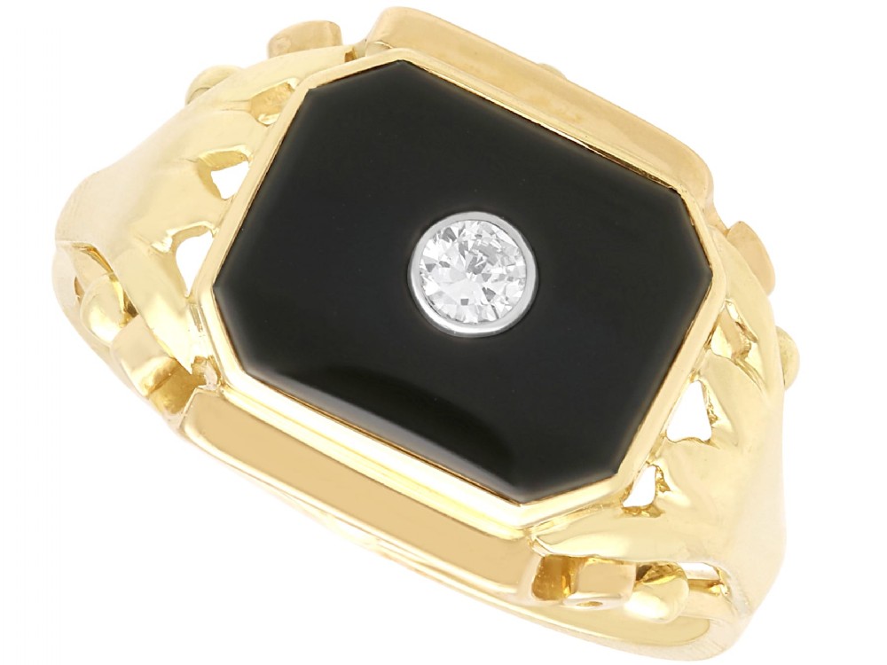 A 14ct yellow gold signet ring set with an octagonal black onyx plaque featuring a central round diamond bezel setting.