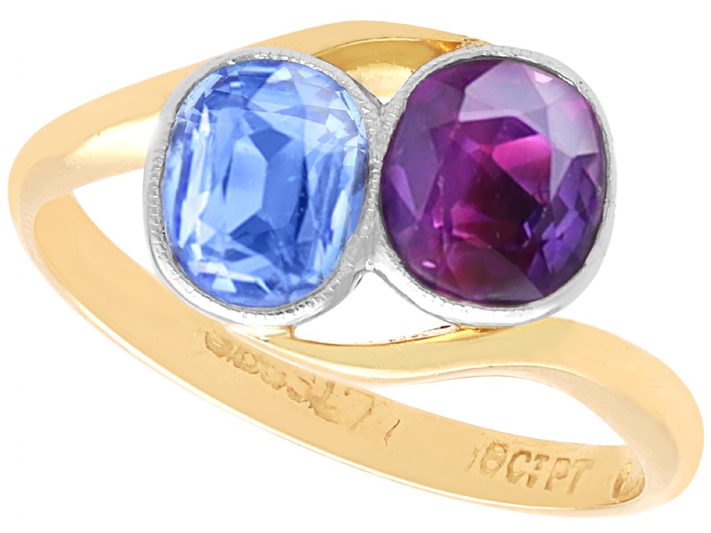 An Edwardian 18ct yellow gold twist ring set with a cushion cut blue sapphire and pink sapphire in platinum settings.