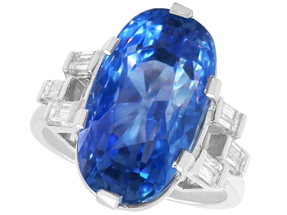 A large oval blue Ceylon sapphire set in platinum with stepped baguette diamond shoulders.